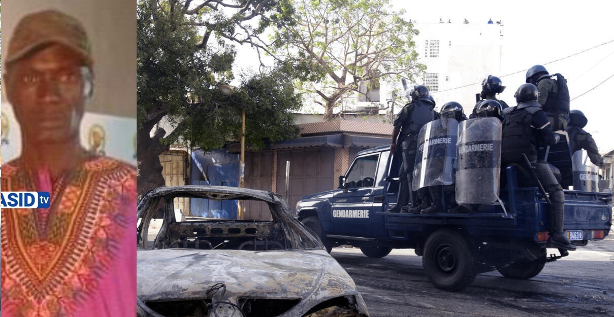 Gendarmerie's truck drives past a burnt vehicle in the streets of Dakar on March 5, 2021 during clashes following the arrest of main opposition leader Ousmane Sonko. (Photo by Seyllou / AFP)