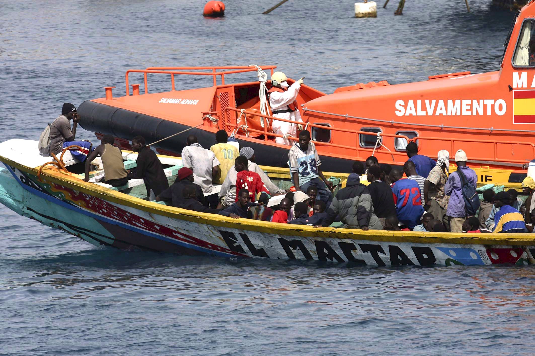 epa01155568 A sea rescue ship tows a small boat with 105 Sub Saharan illegal immigrants on board towards Arona port in Tenerife island, the Canaries, Spain, 24 October 2007. The immigrant's boat was sighted 30 miles from the island.  EPA/MANUEL LERIDA