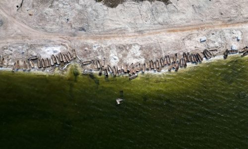 Pirogues lie on the bank of the Pink Lake (Lac Rose), officially known as Lake Retba after extreme floods washed away salt mounts and contaminated the lake and turned its famous waters from Pink to green, in Niaga, near Dakar, Senegal, January 17, 2023. REUTERS/ Zohra Bensemra     TPX IMAGES OF THE DAY